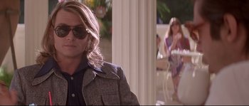 Movie still from “Blow” (2001), directed by Ted Demme – A man with long blonde hair wearing a jacket; Medium shot, Low angle