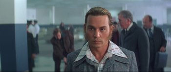 Movie still from “Blow” (2001), directed by Ted Demme – A man with long blonde hair wearing a plaid shirt; Close Up shot, Low angle