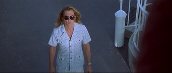Movie still from “Blow” (2001), directed by Ted Demme – A man with long blonde hair wearing sunglasses and a plaid shirt; Medium shot, Low angle