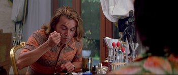 Movie still from “Blow” (2001), directed by Ted Demme – A man sitting at a dining table eating food; Close Up shot, Low angle