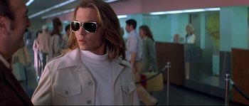 Movie still from “Blow” (2001), directed by Ted Demme – A woman wearing sunglasses and a white jacket; Close Up shot, Low angle