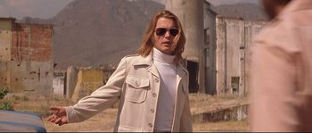 Movie still from “Blow” (2001), directed by Ted Demme – A man in sunglasses and a white jacket standing in a field; Medium shot, Low angle