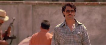 Movie still from “Blow” (2001), directed by Ted Demme – A man in a plaid shirt wearing sunglasses; Close Up shot, Low angle