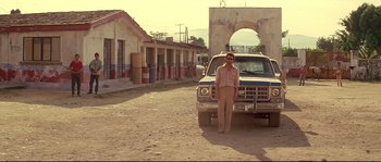 Movie still from “Blow” (2001), directed by Ted Demme – A man standing in front of an old truck; Wide shot, Low angle