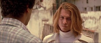 Movie still from “Blow” (2001), directed by Ted Demme – A man with long blonde hair wearing a white jacket; Close Up shot, Over the shoulder angle