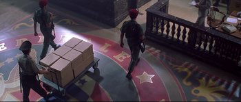 Movie still from “Blow” (2001), directed by Ted Demme – A man walking on the floor of a building with boxes; Wide shot, High angle
