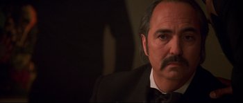 Movie still from “Blow” (2001), directed by Ted Demme – A person wearing a suit and tie; Close Up shot, Low angle