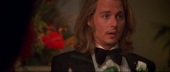 Movie still from “Blow” (2001), directed by Ted Demme – A person wearing a suit and bow tie; Close Up shot, Over the shoulder angle