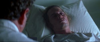 Movie still from “Blow” (2001), directed by Ted Demme – A man laying in a hospital bed with his eyes closed; Close Up shot, High angle