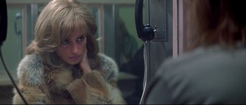 Movie still from “Blow” (2001), directed by Ted Demme – A woman sitting on top of a bus with her hand on her face; Close Up shot, High angle