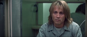 Movie still from “Blow” (2001), directed by Ted Demme – A man with long blonde hair sitting in front of a mirror; Close Up shot, Over the shoulder angle