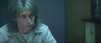 Movie still from “Blow” (2001), directed by Ted Demme – A person with long hair sitting in front of a wall; Close Up shot, Over the shoulder angle