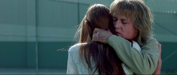 Movie still from “Blow” (2001), directed by Ted Demme – Two people hugging each other in front of a building; Close Up shot, Low angle