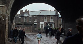 Movie still from “Blow-Up” (1966), directed by Michelangelo Antonioni – A group of people walking down a sidewalk; Extreme Wide shot, High angle