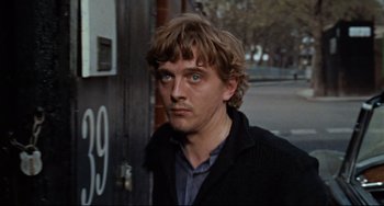 Movie still from “Blow-Up” (1966), directed by Michelangelo Antonioni – A person wearing a jacket; Close Up shot, Over the shoulder angle