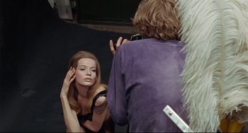 Movie still from “Blow-Up” (1966), directed by Michelangelo Antonioni – A woman is taking a picture of another woman in front of a mirror; Medium shot, Over the shoulder angle