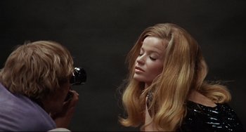 Movie still from “Blow-Up” (1966), directed by Michelangelo Antonioni – A woman with long blonde hair being photographed by a photographer; Close Up shot, Low angle