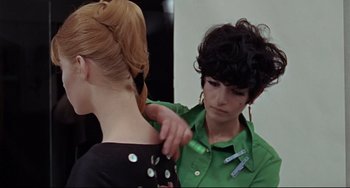 Movie still from “Blow-Up” (1966), directed by Michelangelo Antonioni – A woman in a green shirt is getting her hair done; Close Up shot, Over the shoulder angle