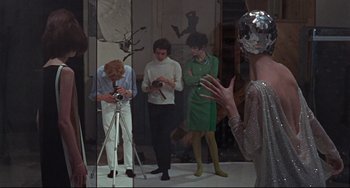Movie still from “Blow-Up” (1966), directed by Michelangelo Antonioni – A group of people standing in front of a mirror; Medium shot, High angle