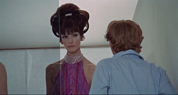 Movie still from “Blow-Up” (1966), directed by Michelangelo Antonioni – A woman standing in front of a mirror next to a man; Medium shot, Over the shoulder angle