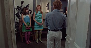 Movie still from “Blow-Up” (1966), directed by Michelangelo Antonioni – Two women and a man standing in front of a mirror; Wide shot, Over the shoulder angle