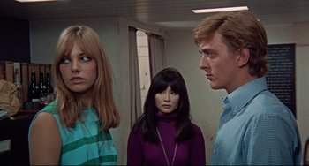 Movie still from “Blow-Up” (1966), directed by Michelangelo Antonioni – A group of people standing next to each other in a room; Medium shot, Low angle
