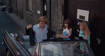 Movie still from “Blow-Up” (1966), directed by Michelangelo Antonioni – A man and a woman in the back of a car; Medium shot, High angle