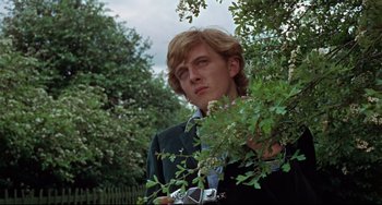Movie still from “Blow-Up” (1966), directed by Michelangelo Antonioni – A man standing next to a tree looking at the camera; Close Up shot, Low angle