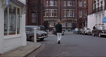 Movie still from “Blow-Up” (1966), directed by Michelangelo Antonioni – A woman walking down the street in front of a building; Wide shot, High angle