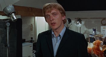 Movie still from “Blow-Up” (1966), directed by Michelangelo Antonioni – A man in a suit and tie in front of a mirror; Close Up shot, Low angle