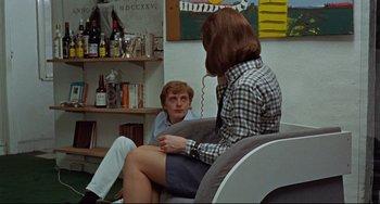 Movie still from “Blow-Up” (1966), directed by Michelangelo Antonioni – A man and a woman sitting in a chair; Medium shot, Over the shoulder angle