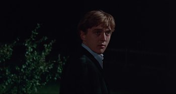 Movie still from “Blow-Up” (1966), directed by Michelangelo Antonioni – A man in a suit and tie standing in the dark; Close Up shot, Low angle