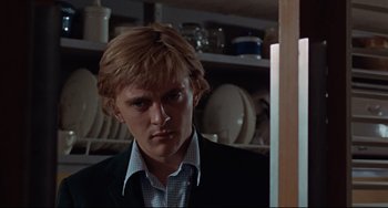 Movie still from “Blow-Up” (1966), directed by Michelangelo Antonioni – A man in a suit and tie standing in front of a mirror; Close Up shot, Low angle