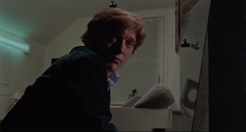 Movie still from “Blow-Up” (1966), directed by Michelangelo Antonioni – A young man in a green jacket is looking at the camera; Close Up shot, Low angle