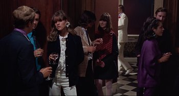 Movie still from “Blow-Up” (1966), directed by Michelangelo Antonioni – A group of people standing in a room with wine glasses; Medium shot, Over the shoulder angle