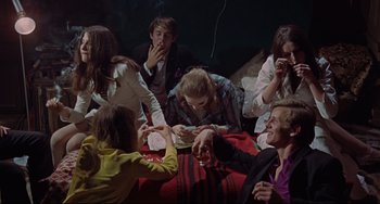 Movie still from “Blow-Up” (1966), directed by Michelangelo Antonioni – A group of people sitting on a blanket eating; Medium shot, High angle