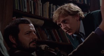 Movie still from “Blow-Up” (1966), directed by Michelangelo Antonioni – Two men in front of a book shelf with books; Close Up shot, Low angle