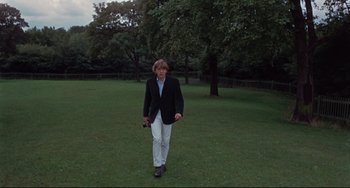 Movie still from “Blow-Up” (1966), directed by Michelangelo Antonioni – A man in a jacket is standing in a field; Wide shot, High angle