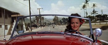 Movie still from “Blue Hawaii” (1961), directed by Norman Taurog – A woman sitting in the passenger seat of a red car; Medium shot, Low angle