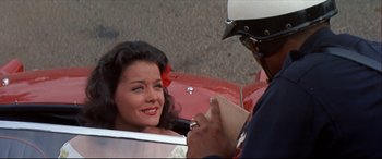Movie still from “Blue Hawaii” (1961), directed by Norman Taurog – A woman sitting in the back of a red car; Close Up shot, Over the shoulder angle