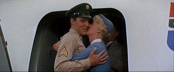 Movie still from “Blue Hawaii” (1961), directed by Norman Taurog – A couple of people that are kissing in the air; Medium shot, Low angle