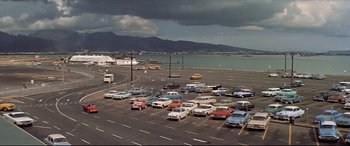 Movie still from “Blue Hawaii” (1961), directed by Norman Taurog – A parking lot filled with lots of cars next to a body of water; Extreme Wide shot, High angle