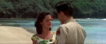 Movie still from “Blue Hawaii” (1961), directed by Norman Taurog – A man and a woman standing next to each other on the beach; Medium shot, Over the shoulder angle