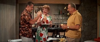 Movie still from “Blue Hawaii” (1961), directed by Norman Taurog – A group of people standing in a room eating food; Medium shot, High angle