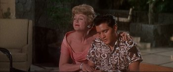 Movie still from “Blue Hawaii” (1961), directed by Norman Taurog – An older woman sitting next to an older man; Medium shot, Low angle