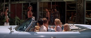 Movie still from “Blue Hawaii” (1961), directed by Norman Taurog – A group of people sitting in the back of a car; Wide shot, Over the shoulder angle