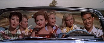 Movie still from “Blue Hawaii” (1961), directed by Norman Taurog – A group of women sitting in the back seat of a car; Medium shot, Low angle
