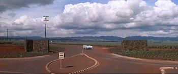 Movie still from “Blue Hawaii” (1961), directed by Norman Taurog – A car driving down a road under a cloudy sky; Extreme Wide shot, High angle