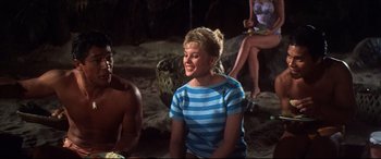 Movie still from “Blue Hawaii” (1961), directed by Norman Taurog – A young woman sitting on the beach at night; Medium shot, High angle