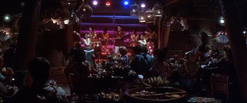Movie still from “Blue Hawaii” (1961), directed by Norman Taurog – A group of people are gathered around a table; Wide shot, High angle